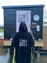 Load image into Gallery viewer, Back of black cotton towelie, showing &#39;The Hot Box Sauna&#39; logo
